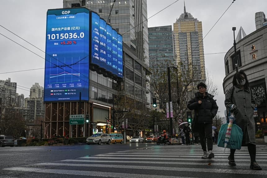 La gente pasa frente a una pantalla que muestra las cifras del PIB en una calle de Shanghái el 19 de enero de 2026. (Jade Gao/AFP vía Getty Images)
