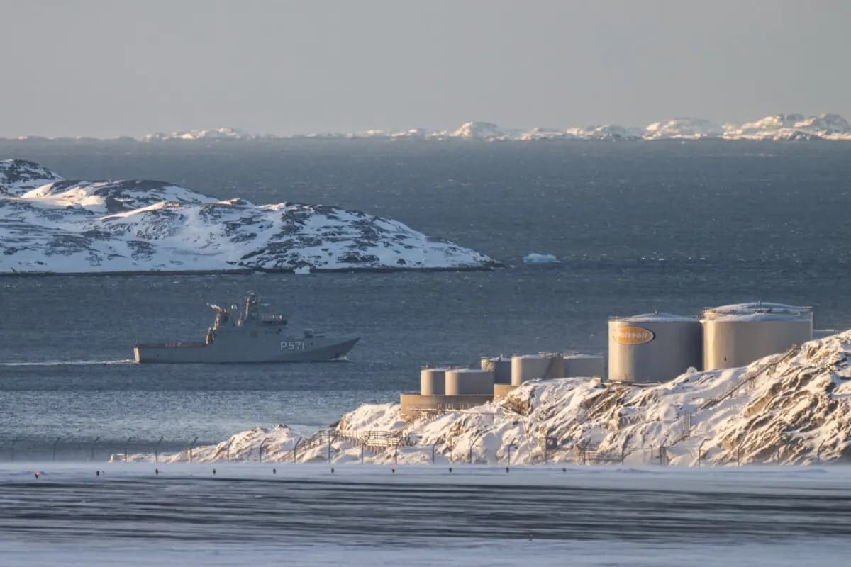 Un barco patrullero con la inscripción "P571" navega junto a los tanques de almacenamiento de combustible a lo largo de la costa cerca del aeropuerto de Nuuk, con islas cubiertas de nieve al fondo, en Nuuk, Groenlandia, el 20 de enero de 2026. (Jonathan Nackstrand/ AFP vía Getty Images)