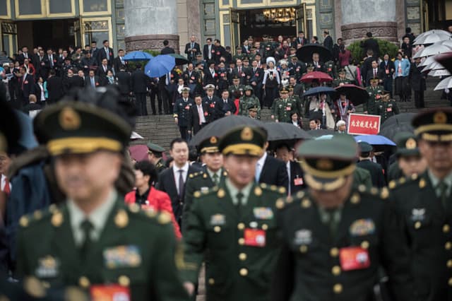 Militares chinos abandonan la sala tras discurso del líder chino Xi Jinping en el XIX Congreso del Partido Comunista, celebrado en Pekín el 18 de octubre de 2017. El Partido Comunista de China inauguró su XIX Congreso Nacional el 18 de octubre, una reunión política que se celebra dos veces por década y dura una semana, con el fin de reorganizar los puestos de liderazgo. (Foto de FRED DUFOUR/AFP vía Getty Images).