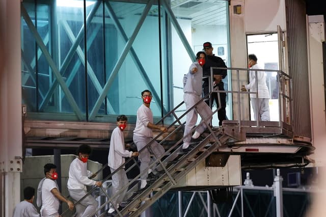 Migrantes venezolanos deportados suben las escaleras hacia la pasarela después de desembarcar del vuelo de repatriación en el Aeropuerto Internacional Simón Bolívar el 20 de febrero de 2025 en La Guaira, Venezuela. (Javier Campos/Getty Images)