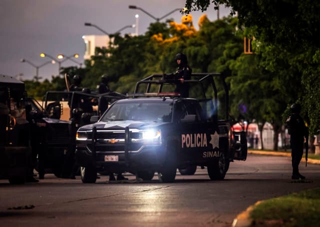 Policías mexicanos patrullan una calle de Culiacán, estado de Sinaloa, México, el 17 de octubre de 2019, después de que hombres fuertemente armados en camionetas 4x4 libraran una intensa batalla con las fuerzas de seguridad mexicanas. (RASHIDE FRIAS/AFP via Getty Images)