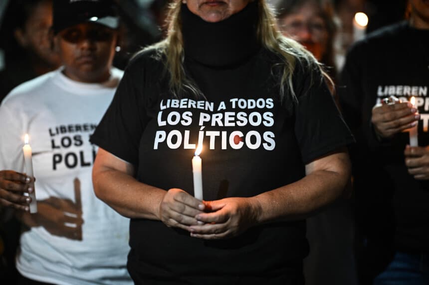 Una mujer enciende una vela durante una vigilia para exigir la libertad de los presos políticos venezolanos frente a la Zona 7 de la prisión de la Policía Nacional Bolivariana (PNB) en Caracas, el 21 de enero de 2026. (Ronaldo SCHEMIDT / AFP vía Getty Images)