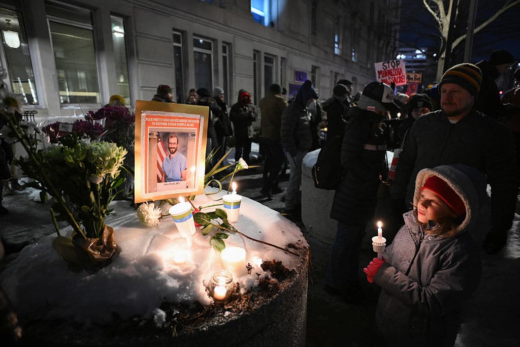 Un niño sostiene una vela junto a un memorial improvisado en honor a Alex Pretti, frente al Departamento de Asuntos de Veteranos de Estados Unidos en Washington D. C., el 28 de enero de 2026. (Foto de Mandel NGAN / AFP a través de Getty Images)