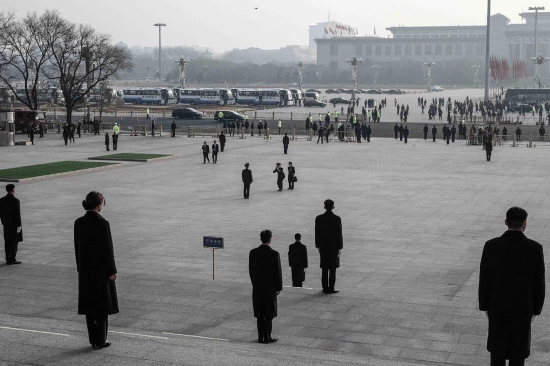 El personal de seguridad vigila las escaleras mientras los delegados del ejército chino toman fotografías a su llegada a la segunda sesión plenaria del Congreso Nacional del Pueblo en el Gran Salón del Pueblo en Beijing, China, el 8 de marzo de 2025. (Kevin Frayer/Getty Images)