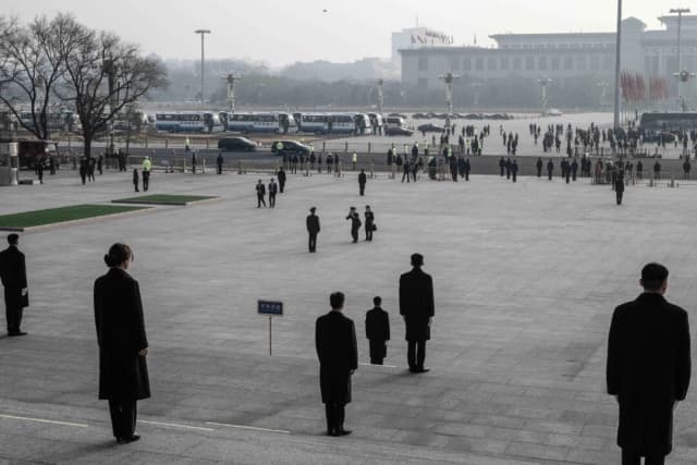 El personal de seguridad vigila las escaleras mientras los delegados del ejército chino toman fotografías a su llegada a la segunda sesión plenaria del Congreso Nacional del Pueblo en el Gran Salón del Pueblo en Beijing, China, el 8 de marzo de 2025. (Kevin Frayer/Getty Images)