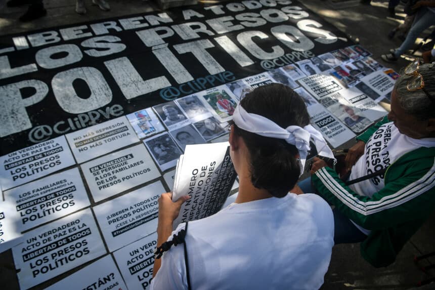 Familiares de presos colocan fotografías y una pancarta con el lema "Liberen a todos los presos políticos" durante una protesta frente a la Fiscalía General de la República en la Plaza Parque Carabobo, el 20 de enero de 2026, en Caracas, Venezuela. (Carlos Becerra/Getty Images)
