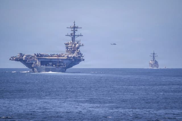 Un MH-60R Sea Hawk, asignado al Escuadrón de Helicópteros de Ataque Marítimo (HSM) 71, vuela entre el portaaviones USS Abraham Lincoln (CVN 72) de clase Nimitz y el destructor de misiles guiados USS Spruance (DDG 111) de clase Arleigh Burke, que transita por el estrecho de San Bernardino en formación con el destructor de misiles guiados USS Frank E. Petersen Jr. (DDG 121), también de clase Arleigh Burke, el 25 de diciembre de 2025. (Christian Kibler, especialista en comunicación de masas de tercera clase/Marina de los EE. UU.)