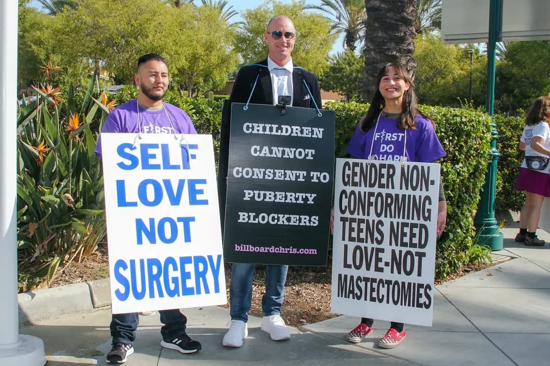 (De izquierda a derecha) Abel García, Billboard Chris y Chloe Cole participan en una manifestación en Anaheim, California, el 8 de octubre de 2022. García, que tenía 19 años en 2016 cuando comenzó el tratamiento hormonal y se sometió a un implante mamario para parecer más femenino, dijo que el veredicto de Varian era un paso en la dirección correcta. (Brad Jones/The Epoch Times)