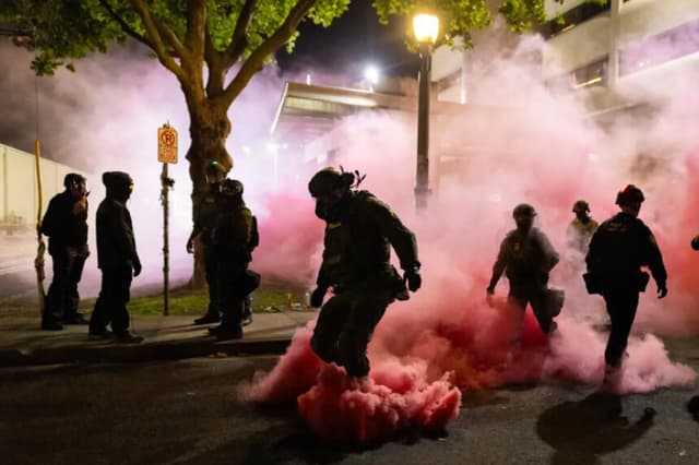 Agentes federales lanzan granadas de humo para disuadir a los manifestantes frente a las oficinas del Servicio de Inmigración y Control de Aduanas en Portland, Oregón, el 5 de octubre de 2025. (John Fredricks/The Epoch Times).