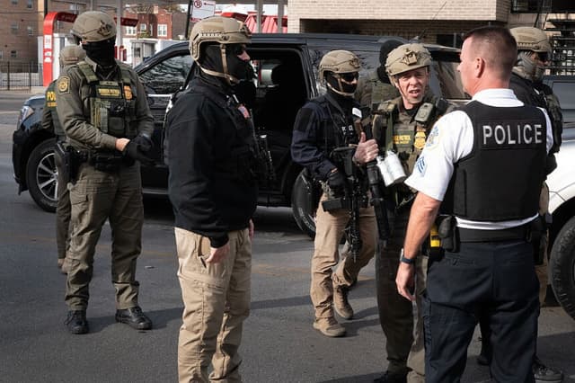 El jefe de la Patrulla Fronteriza, Greg Bovino, habla con un agente de policía de Chicago mientras busca inmigrantes indocumentados en un barrio del suroeste de la ciudad el 6 de noviembre de 2025 en Chicago, Illinois. (Foto de Scott Olson/Getty Images).