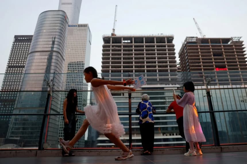 La gente visita la terraza de un centro comercial con vistas al distrito central de negocios (CBD) de Beijing, el 11 de agosto de 2025. (Tingshu Wang/Reuters)