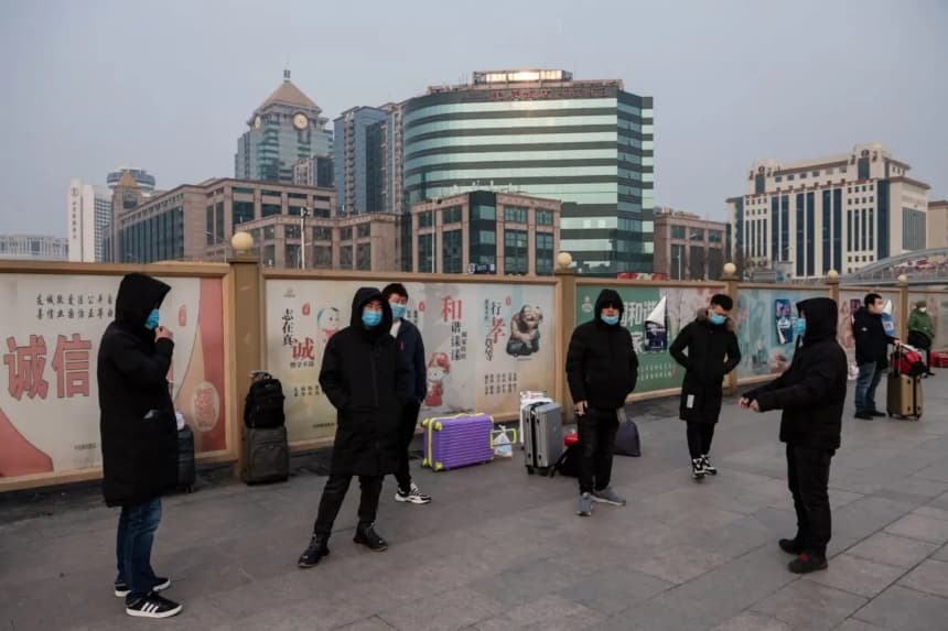 Personas con mascarillas esperan junto a sus maletas en una estación de tren de Beijing, el 27 de enero de 2020. (Nicolas Asfouri/AFP a través de Getty Images)