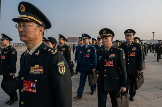 Diputados del ejército chino caminan juntos a su llegada a la segunda sesión plenaria del Congreso Nacional del Pueblo (APN) en el Gran Salón del Pueblo, en Pekín, China, el 8 de marzo de 2025. (Kevin Frayer/Getty Images)