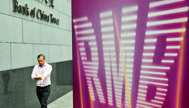 Un empresario pasa junto a un cartel del renminbi (RMB) fuera del Banco de China en Hong Kong el 5 de septiembre de 2011. (Laurent Fievet/AFP/Getty Images)
