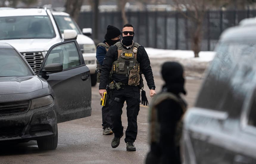 Un agente del ICE sostiene una pistola eléctrica mientras vigilan después de que uno de sus vehículos tuviera un pinchazo en Penn Avenue el 5 de febrero de 2026 en Minneapolis, Minnesota. (Stephen Maturen/Getty Images)