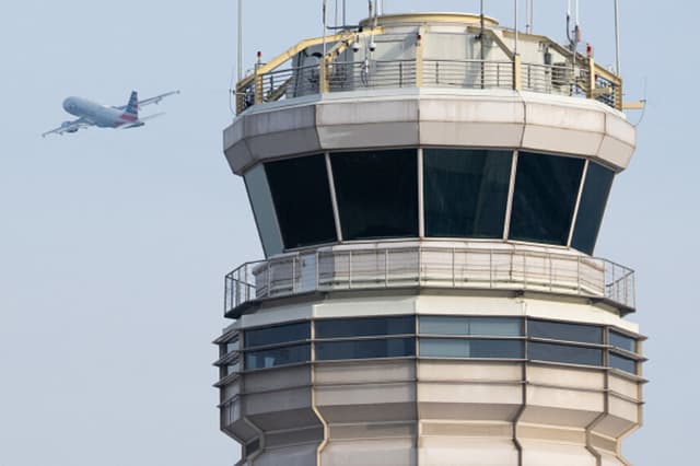 Un avión Airbus A319 de American Airlines despega junto a la torre de control del tráfico aéreo del Aeropuerto Nacional Ronald Reagan de Washington, en Arlington (Virginia), el 11 de enero de 2023. (SAUL LOEB/AFP a través de Getty Images).