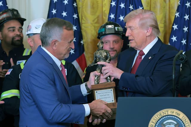 El presidente y director ejecutivo de Peabody Energy, Jim Grech (izquierda), entrega un trofeo al presidente de Estados Unidos, Donald Trump, durante un acto sobre el uso del carbón celebrado en el Salón Este de la Casa Blanca el 11 de febrero de 2026 en Washington, D.C. El grupo de presión Washington Coal Club otorgó a Trump el premio «Campeón indiscutible del carbón». También se espera que Trump firme una orden ejecutiva en la que se ordene al Departamento de Defensa comprar electricidad a centrales eléctricas de carbón. (Foto de Anna Moneymaker/Getty Images)