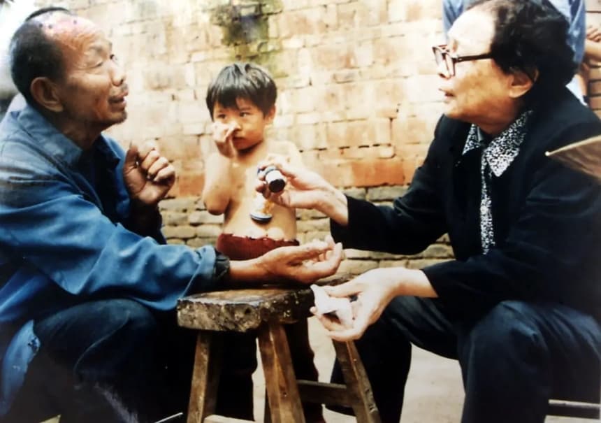 El médico jubilado Gao Yaojie (derecha) aplica un medicamento en el brazo de un aldeano mientras ayuda a personas de aldeas abandonadas afectadas por el sida en la provincia de Henan, en el centro de China, en una foto sin fecha. Un gran número de aldeanos han contraído el sida o el VIH por vender sangre a cambio de dinero. (STR/AFP a través de Getty Images)
