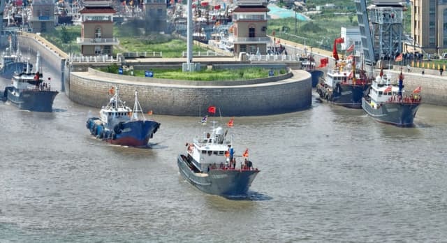Barcos pesqueros se hacen a la mar el primer día de la temporada de pesca en el Mar Amarillo y el Mar de China Oriental, en Nantong, provincia oriental china de Jiangsu, el 1 de agosto de 2022. (STR/AFP vía Getty Images)