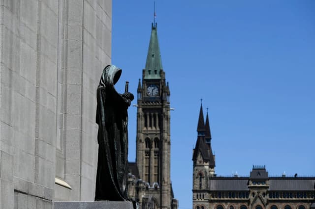 La escultura de Ivstitia (Justicia) en la Corte Suprema de Canadá se ve junto a la Torre de la Paz en Parliament Hill en Ottawa, el 17 de junio de 2021. The Canadian Press/Justin Tang