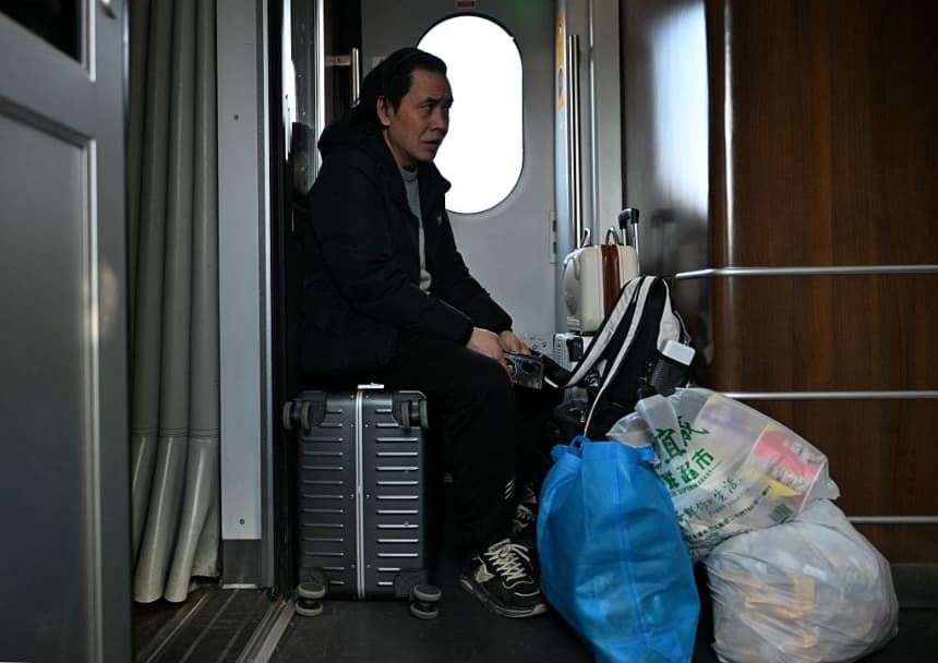 Un pasajero viaja en tren en Beijing el 13 de febrero de 2026, mientras la gente regresa a sus lugares de origen antes de las celebraciones del Año Nuevo Lunar. (AFP vía Getty Images)