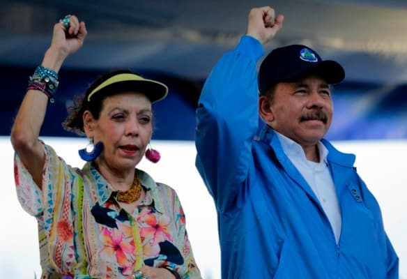 <em>El presidente de Nicaragua, Daniel Ortega, y su esposa, la vicepresidenta Rosario Murillo, levantan los puños durante la conmemoración del 51.º aniversario de la campaña guerrillera de Pancasan en Managua, el 29 de agosto de 2018. (INTI OCON/AFP a través de Getty Images)</em>