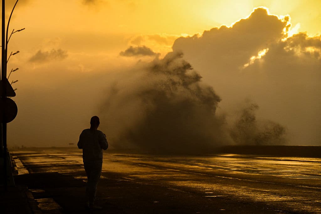 Una mujer mira una gran ola en el Malecón de La Habana el 31 de enero de 2026. (Foto de YAMIL LAGE / AFP vía Getty Images)