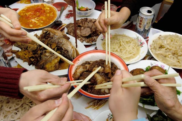 Familias chinas cenan Año Nuevo en Pekín el 8 de febrero de 2005. (China Photos/Getty Images)