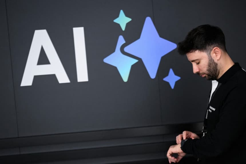 Un hombre mira su reloj junto a un cartel que promociona la Inteligencia Artificial (IA) durante el MWC (Mobile World Congress), la feria de telefonía móvil más grande del mundo, en Barcelona, ​​el 4 de marzo de 2025. (JOSEP LAGO/AFP vía Getty Images)