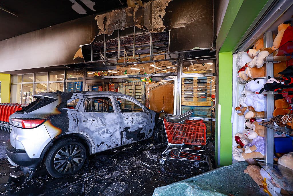 Un auto incendiado impactó la entrada de una tienda en un centro comercial el 22 de febrero de 2026 en Guadalajara, México. Se han reportado bloqueos viales e incendios de vehículos en varias zonas de México desde la madrugada. La Secretaría de la Defensa Nacional confirmó que, durante un operativo de seguridad en Tapalpa, Jalisco, Nemesio Oseguera Cervantes, conocido como "El Mencho", líder del Cártel Jalisco Nueva Generación, fue asesinado junto con otros cuatro miembros. Tres soldados mexicanos resultaron heridos durante el operativo. (Carlos Zepeda/Getty Images)