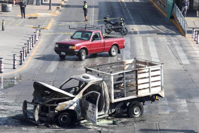 Los restos calcinados de un camión, utilizado como barricada por miembros de un cártel en represalia por el asesinato del famoso líder del cártel "El Mencho" por parte de las fuerzas mexicanas, yacen en Guadalajara, México, el 22 de febrero de 2026. (Michelle Freyria/Reuters)