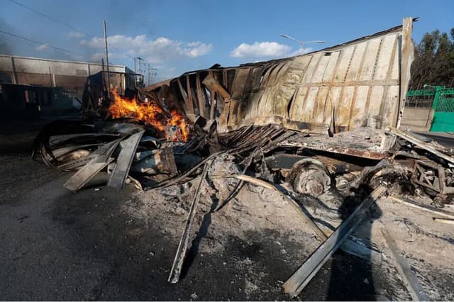 Un camión en llamas, presuntamente incendiado por grupos del crimen organizado en respuesta a un operativo para detener a un objetivo de seguridad de alta prioridad, en una carretera cerca de Acatlán de Juárez, estado de Jalisco, México, el 22 de febrero de 2026. (Ulises Ruiz/AFP vía Getty Images).