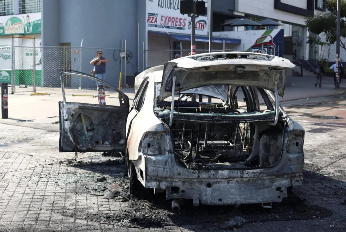 Un vehículo quemado utilizado como barricada por miembros del crimen organizado, tras una serie de detenciones por parte de las fuerzas federales, yace en Guadalajara, México, el 22 de febrero de 2026. (Michelle Freyria/Reuters)