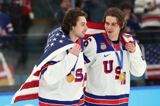 Los medallistas de oro Quinn Hughes #43 y Jack Hughes #86 del equipo de Estados Unidos celebran después de la ceremonia de entrega de medallas de hockey sobre hielo masculino tras el partido por la medalla de oro masculina entre Canadá y Estados Unidos en el día 16 de los Juegos Olímpicos de Invierno Milano Cortina 2026 en el Milano Santagiulia Ice Hockey Arena, en Milán, Italia, el 22 de febrero de 2026. (Bruce Bennett/Getty Images)