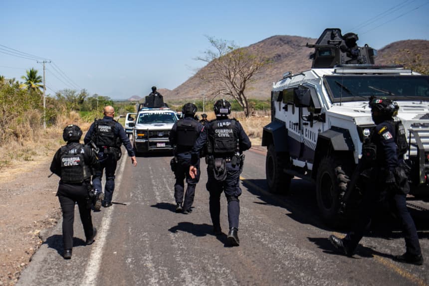 Miembros de la Guardia Civil de Michoacán patrullan una carretera apoyados por vehículos blindados tras una ola de violencia en el municipio de Aguililla —lugar de nacimiento del capo del narcotráfico Nemesio Oseguera, líder del Cártel Jalisco Nueva Generación (CJNG)— en Tierra Caliente, México, el 24 de febrero de 2026.  (Enrique Castro/AFP vía Getty Images)