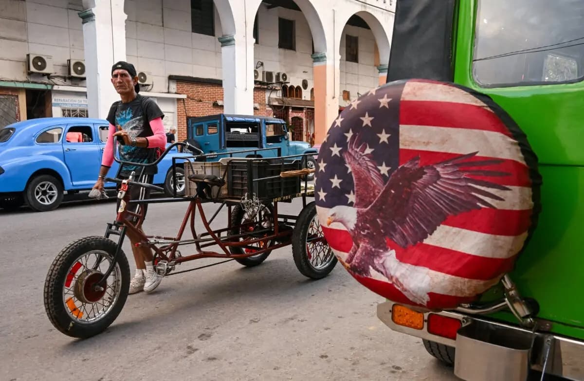 Un hombre empuja un triciclo junto a un jeep con una cubierta de rueda con una imagen basada en la bandera de Estados Unidos, en La Habana, Cuba, el 23 de enero de 2026. (Yamil Lage/AFP vía Getty Images)