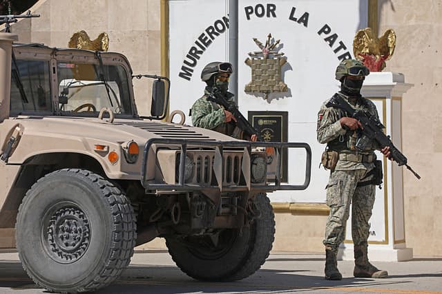 Soldados del Ejército Mexicano custodian las instalaciones de la Guarnición Militar en Ciudad Juárez, Chihuahua, México, el 23 de febrero de 2026. México ha desplegado 10,000 efectivos para sofocar los enfrentamientos provocados por el asesinato del narcotraficante más buscado del país, que han dejado decenas de muertos, informaron las autoridades el 23 de febrero. Nemesio "El Mencho" Oseguera, líder del Cártel Jalisco Nueva Generación (CJNG), resultó herido el 22 de febrero en un tiroteo con soldados en Tapalpa, Jalisco, y murió mientras era trasladado a Ciudad de México, informó el ejército. (Foto de Herika Martinez / AFP vía Getty Images)