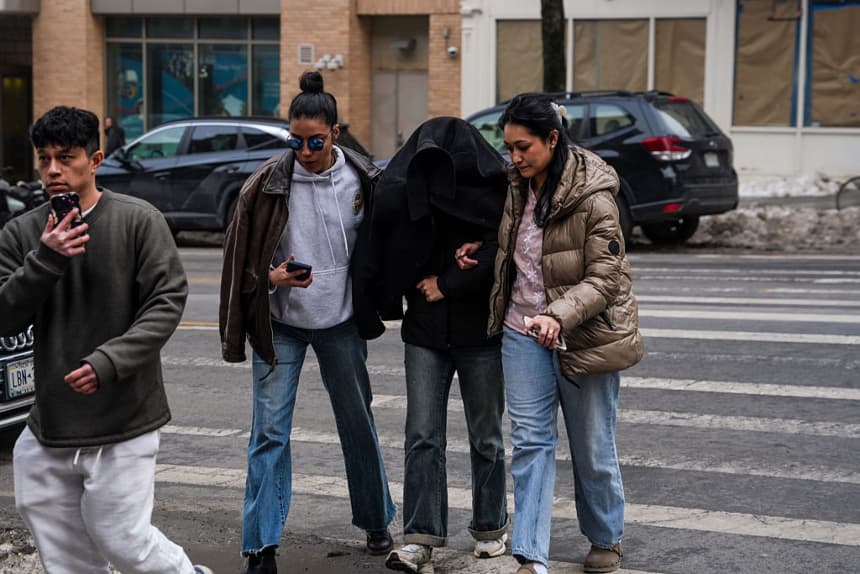 Ellie Aghayeva, estudiante de neurociencia de la Universidad de Columbia, es escoltada a su apartamento con el rostro cubierto tras ser detenida por agentes federales del Departamento de Seguridad Nacional la madrugada del jueves 26 de febrero de 2026 en la ciudad de Nueva York. (Ryan Murphy/Getty Images)