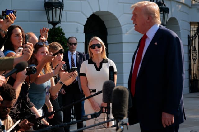 La secretaria de prensa de la Casa Blanca, Karoline Leavitt, observa cómo el presidente de los Estados Unidos, Donald Trump, habla con los periodistas al salir de la Casa Blanca el 25 de julio de 2025 en Washington, D.C. Trump viaja esta semana a sus campos de golf de Balmedie, en Escocia. (Chip Somodevilla/Getty Images).