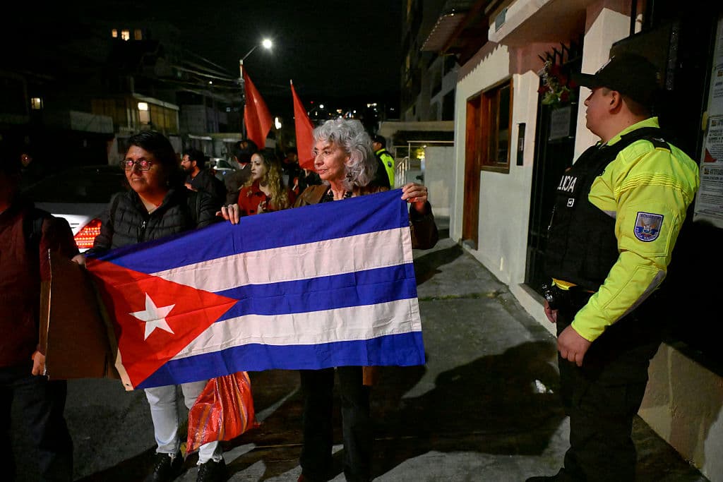La exembajadora ecuatoriana en Cuba (2017-2019), María Augusta Calle (C), protesta junto a simpatizantes del gobierno cubano, sosteniendo una bandera cubana frente a la embajada de Cuba en Quito el 4 de marzo de 2026. Ecuador ordenó la expulsión del embajador de Cuba en Quito, dándole a él y al resto del personal de su embajada 48 horas para abandonar el país, anunció el Ministerio de Relaciones Exteriores. (Foto de Rodrigo BUENDIA / AFP vía Getty Images)
