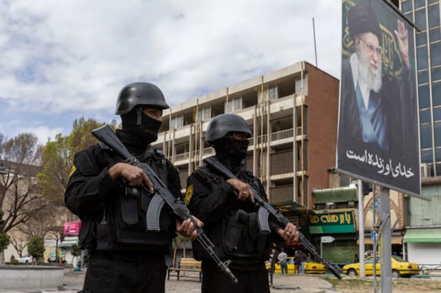 Las fuerzas de seguridad montan guardia cerca de un retrato del ayatolá Alí Jamenei en el centro de Teherán, Irán, el 2 de marzo de 2026. (Majid Saeedi/Getty Images)