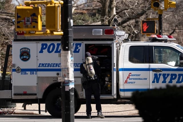 Un agente de la policía de Nueva York con un tanque de oxígeno frente al parque Carl Schurz mientras investigan un artefacto sospechoso en la ciudad de Nueva York el 10 de marzo de 2026. (Yuki Iwamura/AP Photo)
