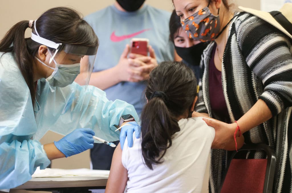 Una niña recibe la vacuna contra la gripe de una enfermera en una clínica gratuita celebrada en una biblioteca local el 14 de octubre de 2020 en Lakewood, California. (Foto de Mario Tama/Getty Images)