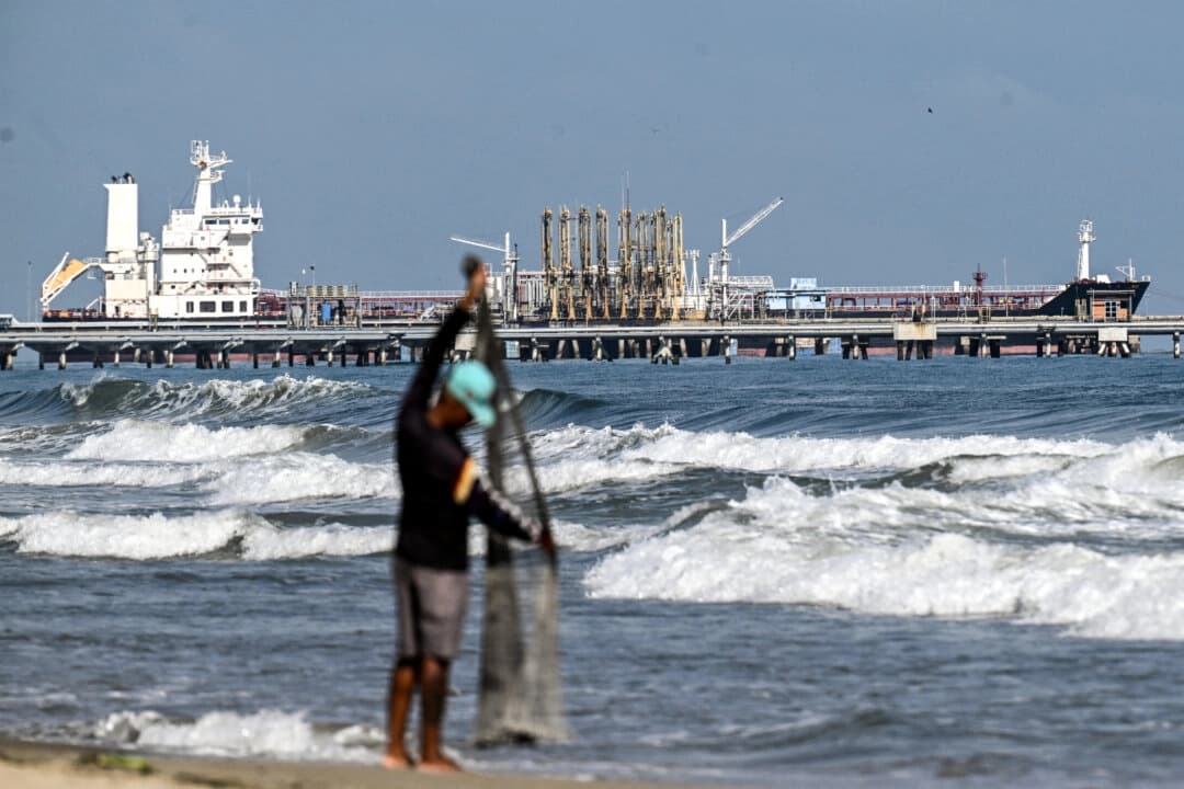 Un pescador permanece junto al mar mientras un buque cisterna atraca en el muelle de la refinería El Palito, en Puerto Cabello, estado Carabobo, Venezuela, el 22 de enero de 2026. (Ronaldo Schemidt /AFP vía Getty Images)