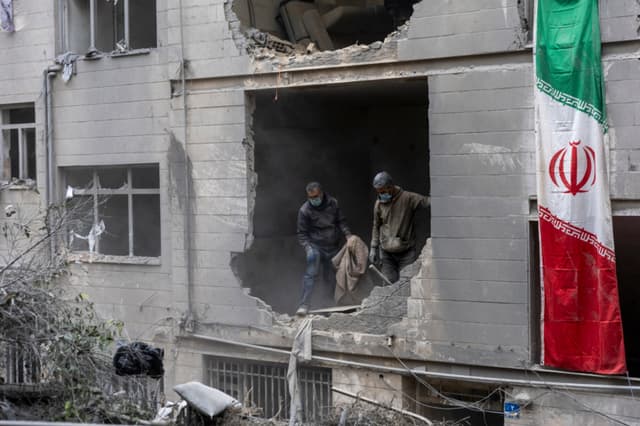 Un grupo de personas retira escombros en una vivienda del distrito de Beryanak tras los daños sufridos por ataques con misiles dos días antes, el 15 de marzo de 2026, en Teherán, Irán. (Majid Saeedi/Getty Images)