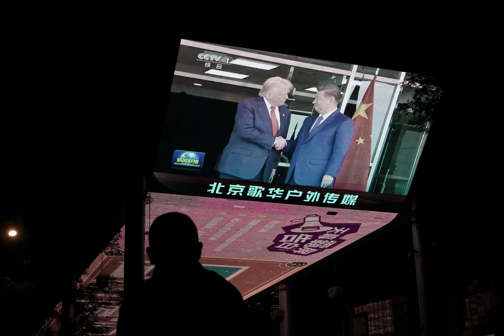 El 30 de octubre de 2025, una pantalla de televisión situada a las afueras de un centro comercial de Beijing muestra la cobertura informativa de la reunión entre el presidente de Estados Unidos, Donald Trump, y el líder chino, Xi Jinping, celebrada en Corea del Sur. (Adek Berry/AFP vía Getty Images).