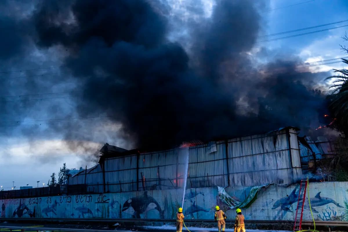 Los bomberos intentan extinguir un incendio en un almacén que se produjo en medio de una lluvia de misiles iraníes en Holón, Israel, el 13 de marzo de 2026. (Erik Marmor/Getty Images).