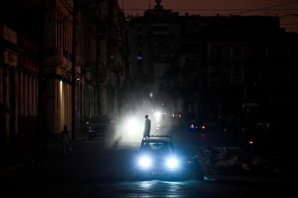 <em>Un hombre camina mientras los autos circulan por una calle durante un apagón en La Habana el 16 de marzo de 2026. Cuba sufrió un corte de energía generalizado el 16 de marzo de 2026, según la compañía eléctrica nacional, en el contexto de una grave crisis en la isla provocada por el bloqueo energético estadounidense. (Foto de Yamil LAGE / AFP vía Getty Images)</em>