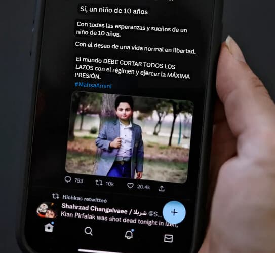 (Una mujer observa en la pantalla de su teléfono una publicación en redes sociales que, según se informa, muestra a un niño iraní que murió en un ataque con disparos a principios de esta semana en la ciudad de Izeh, al oeste de Irán, en Nicosia, Chipre, el 18 de noviembre de 2022. -/AFP vía Getty Images).