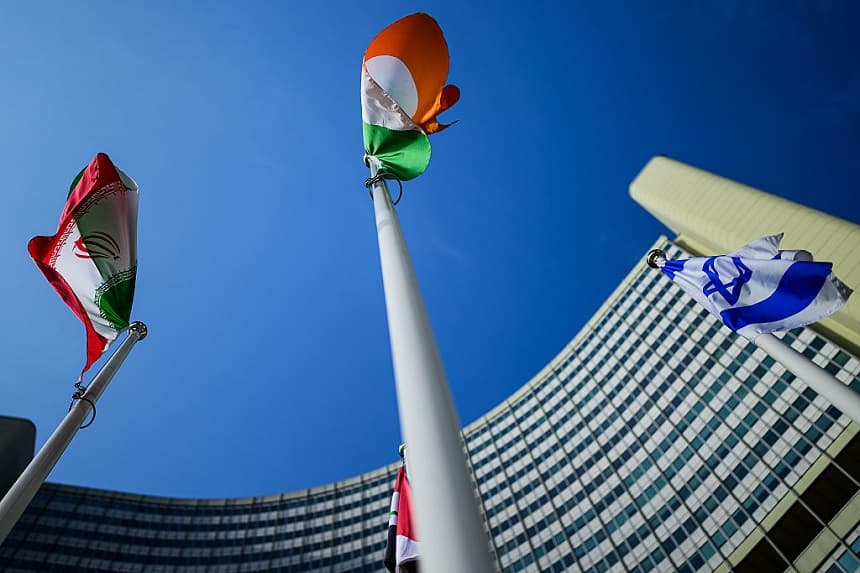 Las banderas de Irán (izquierda) e Israel (derecha) se ven frente a la sede del Organismo Internacional de Energía Atómica (OIEA) durante una reunión de la Junta de Gobernadores del OIEA celebrada el 2 de marzo de 2026 en Viena, Austria. (Christian Bruna/Getty Images)